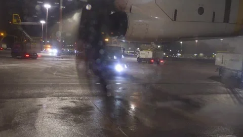 View from airplane window as deicing vehicle sprays aircraft before departure Stock Footage 338187053