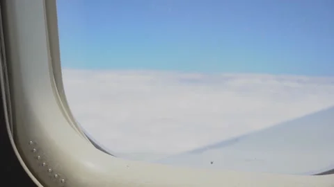 View from airplane window during flight with slight turbulence. White clouds and Stock Footage 224707977
