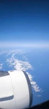 View from the airplane window of the endless sky, clouds and part of the engine Stock Photos