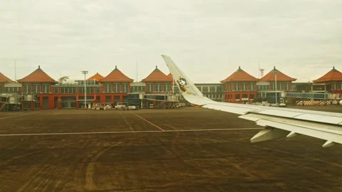 View from airplane window of flight wing, with Balinese architecture departure 스톡 동영상 334188019