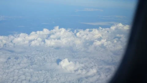 A view from an airplane window of fluffy clouds stretching across a clear b.. 스톡 동영상 291170856
