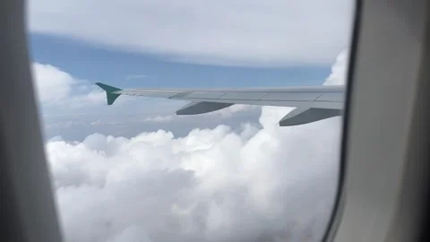 View from airplane window flying between two layers of white clouds Stock Footage 246972902