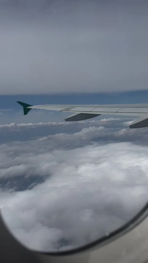 View from airplane window flying between two layers of white clouds. Vertical Stock Footage 246972956