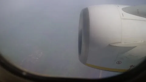 View From Airplane Window Focusing on Engine While Cruising Through Sky on Sunny Stock Footage 303009330