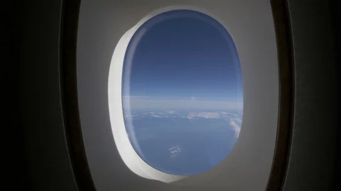 View from airplane window frame onto blue sea and sky with white clouds Stock Footage 84791956