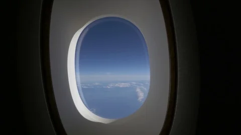 View from airplane window frame onto blue sea and sky with white clouds Stock Footage 84977672