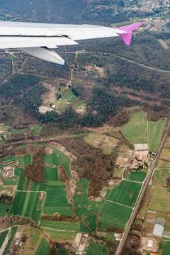 View from the airplane window on green fields and forests on the background of 스톡 사진