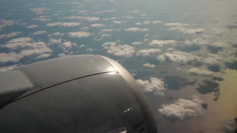 View from the airplane window on jet engine, clouds and sea or ocean below. Stockbeeldmateriaal 232961252