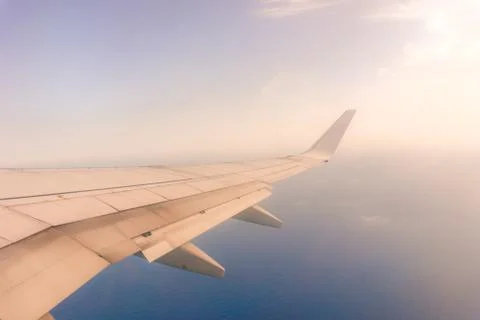 View from the airplane window, ocean blue, sunny day. Vacation concept Stock Photos