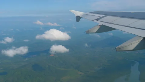 View from airplane window over clouds and hills Video stock 319957902