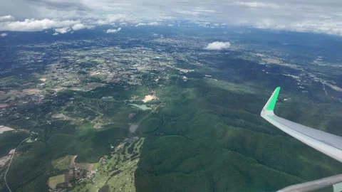 A view from an airplane window, overlooking a vast mountain landscape below. Stock-Footage 311720172