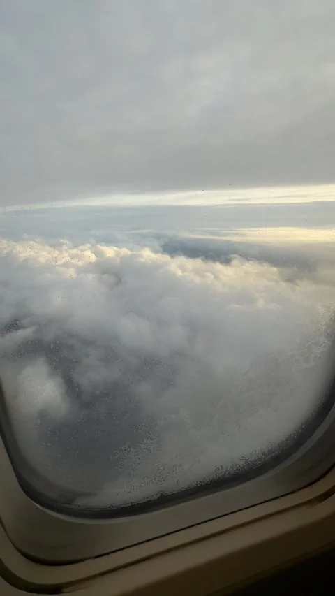 View from airplane window showing clouds and sky during flight at high altitude Stock Footage 297373577
