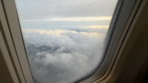 View from airplane window showing clouds and sky during flight at high altitude Stock Footage 297373578