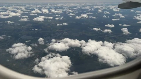 View from airplane window showing scattered clouds over green Polish landscape Stock Footage 310677533