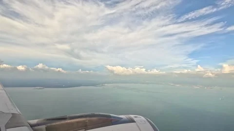 View from Airplane Window Showing Sea and Ships Below with Clouds Stock Footage 339895437