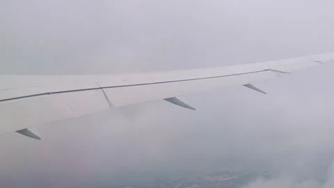 A view from an airplane window showing wing and clouds during flight in 4k .. Stock Footage 282881102