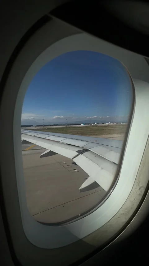 View from airplane window showing the wing as the plane taxis to the runway,  Video stock 321764045