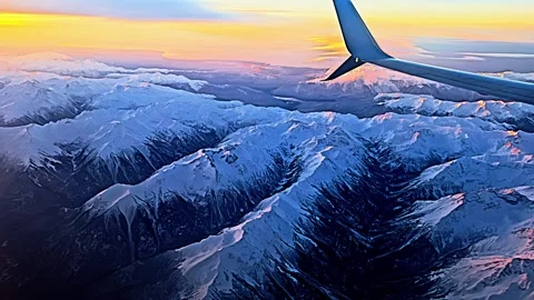 View from the airplane window to sunset, clouds, mountains. 库存影片 259549665