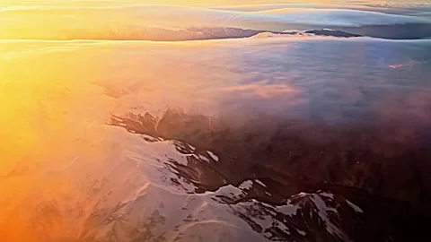 View from the airplane window to sunset, clouds, mountains. 库存影片 259838658