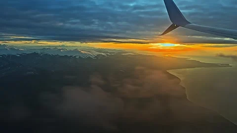 View from the airplane window to sunset, clouds, mountains. Stock Footage 261021197