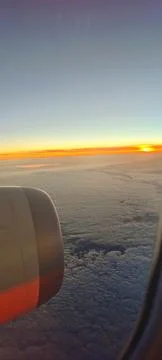 A view from an airplane window of a sunset or sunrise above a layer of cumulus 스톡 사진