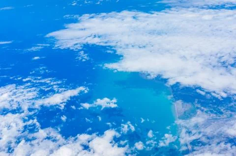 View from an airplane window on white clouds and sea shore Foto stock
