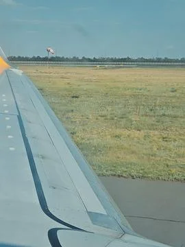 View from airplane window of wing and grass during takeoff. vertical photo,.. Foto stock