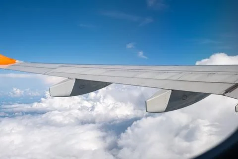 View from airplane window on wing and landscape with clouds on window durin.. Stock Photos