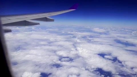 View of Airplane Wing and Clouds from Window Seat during Plane Travel Stock Footage 333390005