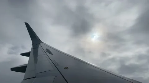 View of an airplane wing and the sky with clouds from the porthole Stock Footage 139745248