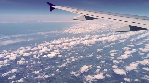 The view of the airplane wing, clouds and Earth's surface from the plane wind Stock Footage 282237048