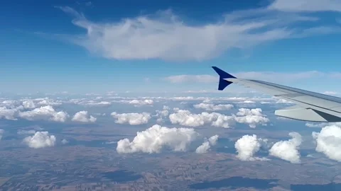 The view of the airplane wing, clouds and Earth's surface from the plane wind Stock Footage 282237051