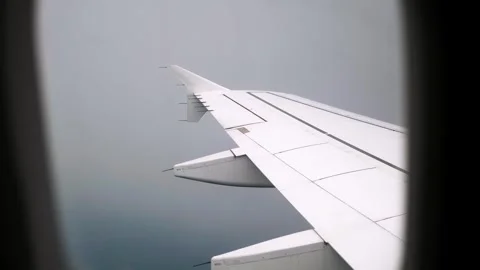 View on an airplane wing in clouds through a porthole. Cloudy sky. Turbulence Video stock 338184849