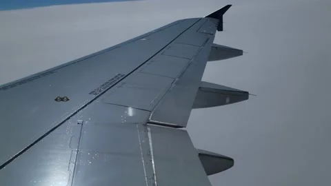 View from airplane wing on a cloudy day. People talking in the background Stock Footage 236427638