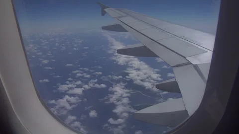 View of an airplane wing in full flight from the window, above the ocean Stock Footage 297885145