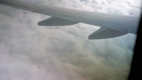 View of airplane wing from inside flying through white puffy clouds Stock Footage 226007412