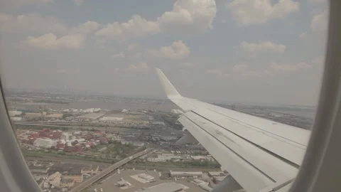 View of Airplane Wing Outside of Window Landing On Runway Stock Footage 100838962