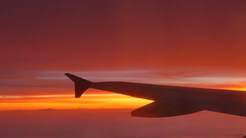 View on airplane wing over the clouds at scenic sunset - 4K, Handheld, Audio Stock Footage 195933372
