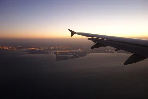View of an airplane wing from a passenger window during flight above the sea at  Stock Photos
