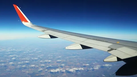 View of an airplane wing from the window against the backdrop of a cloudy sky Stock Footage 166028329