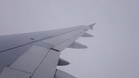 View of the airplanes wing and the clouds out of airplanes window Video stock 105454721