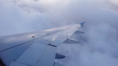 View of the airplanes wing and the clouds out of airplanes window Video stock 105454819