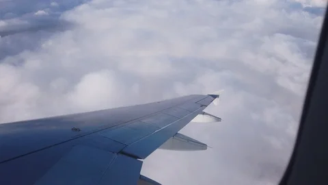 View of the airplanes wing and the clouds out of airplanes window Video stock 105455063