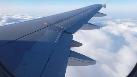 View of the airplanes wing and the clouds out of airplanes window Video stock 105455361