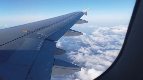 View of the airplanes wing and the clouds out of airplanes window Video stock 105455589