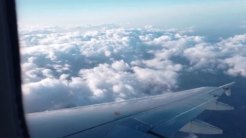 View of the airplanes wing and the clouds out of airplanes window Video stock 105455615