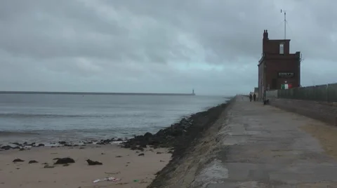View along breakwater on cloudy windy winter's day, pan to opposite breakwater Stock Footage 1091196