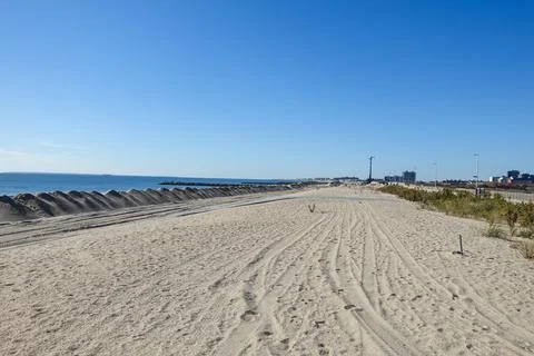 View along the ocean coastline empty beach with piles of sand near the ocea.. Stock Photos