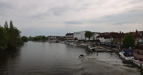 View along a river lined with buildings, moored boats, and people, with a small Stock Footage 308418441