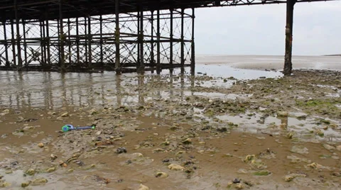 View Along Sandy, Stoney Beach With The Underneath Of Wooden The Pier Stock Footage 36742401